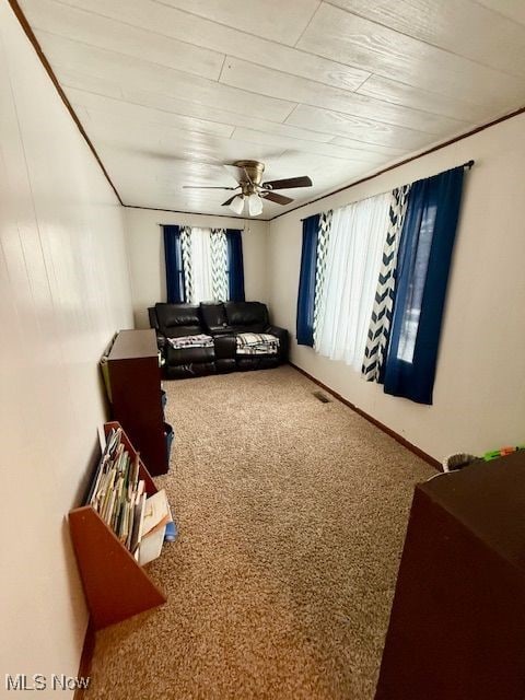 carpeted living room featuring ceiling fan and wood ceiling