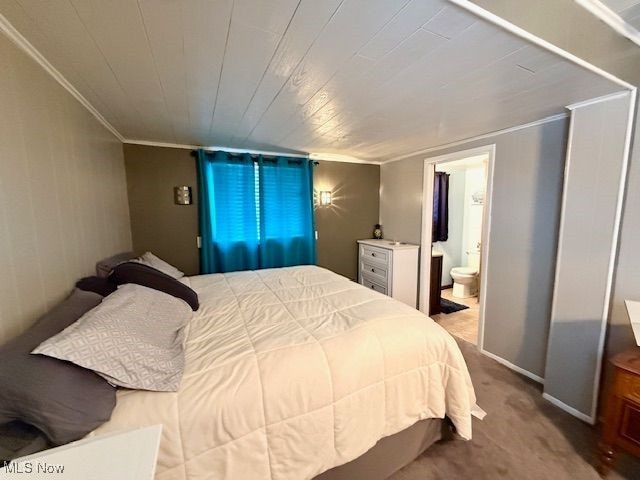 bedroom featuring ensuite bathroom, crown molding, and carpet flooring