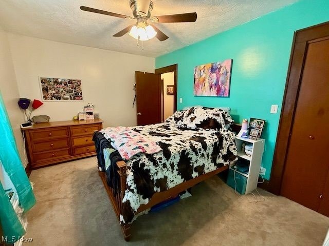 carpeted bedroom with a textured ceiling and ceiling fan