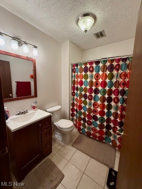 bathroom featuring toilet, vanity, tile patterned floors, and a shower with shower curtain