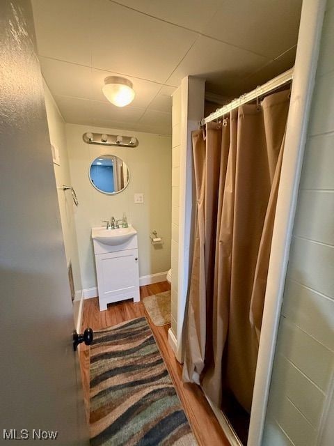 bathroom featuring walk in shower, vanity, and hardwood / wood-style flooring