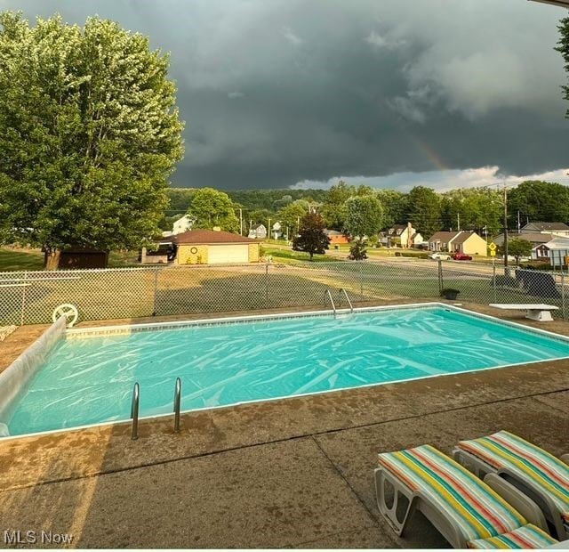 view of swimming pool featuring a diving board