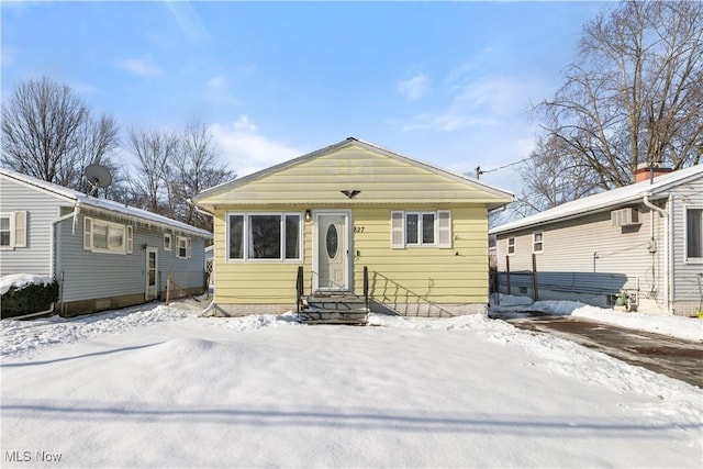 bungalow-style house with a wall unit AC