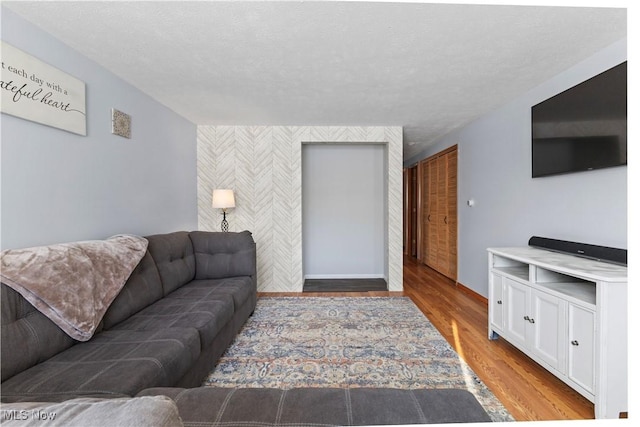 living room featuring a textured ceiling and light hardwood / wood-style floors