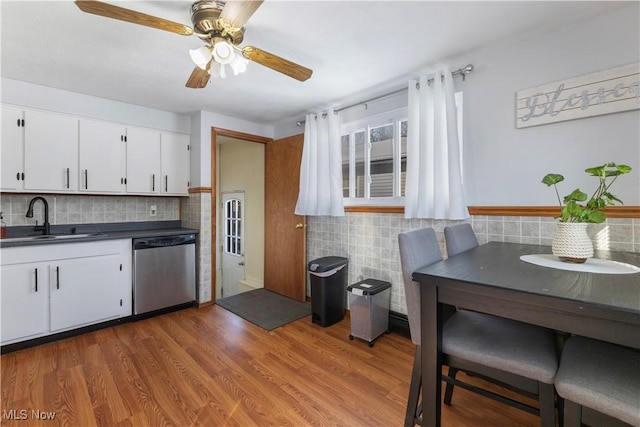 kitchen with white cabinetry, ceiling fan, light wood-type flooring, stainless steel dishwasher, and sink