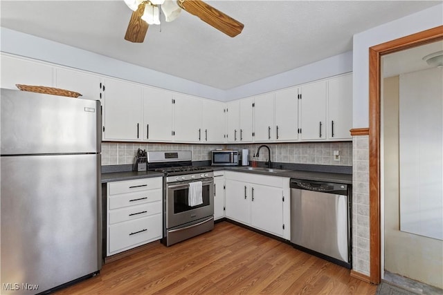 kitchen with white cabinetry, light hardwood / wood-style floors, ceiling fan, appliances with stainless steel finishes, and sink