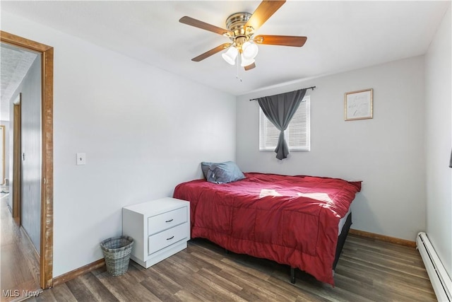 bedroom featuring ceiling fan, baseboard heating, and dark hardwood / wood-style floors