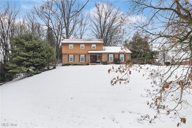 view of snow covered back of property