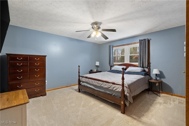 carpeted bedroom with ceiling fan and a textured ceiling