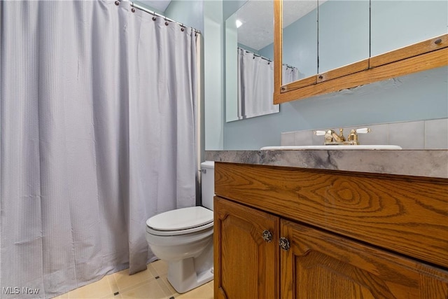 bathroom with toilet, tile patterned floors, and vanity