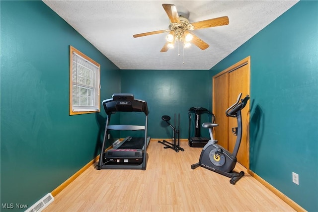 workout area with a textured ceiling, ceiling fan, and hardwood / wood-style floors