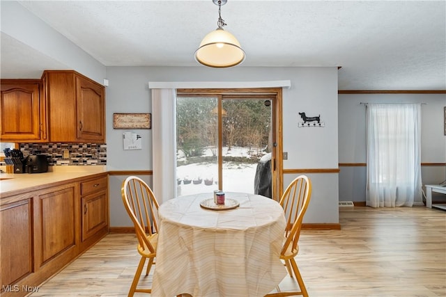 dining area featuring a textured ceiling and light wood-type flooring