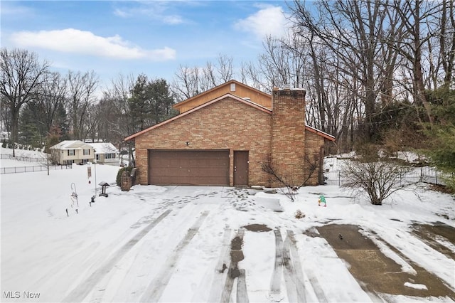 view of snowy exterior with a garage