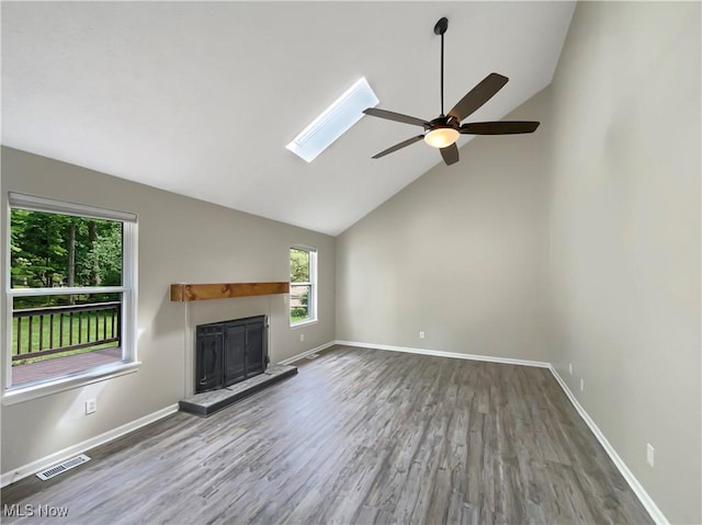 unfurnished living room with ceiling fan, hardwood / wood-style floors, high vaulted ceiling, and a skylight