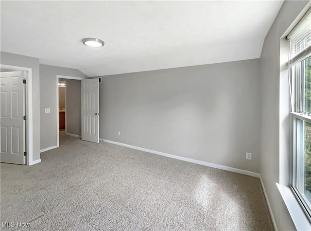 empty room with a wealth of natural light and lofted ceiling