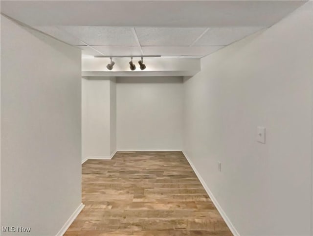 basement with hardwood / wood-style flooring, track lighting, and a drop ceiling