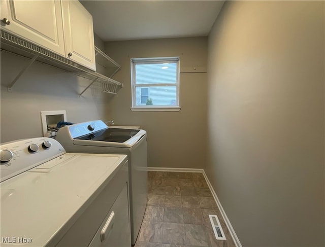 laundry room with washing machine and dryer and cabinets