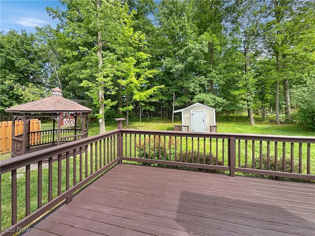 deck featuring a storage shed, a gazebo, and a yard