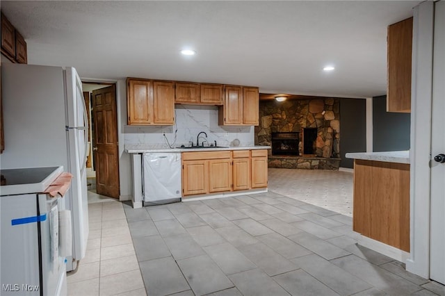 kitchen featuring light tile patterned floors, electric stove, a fireplace, stainless steel dishwasher, and sink