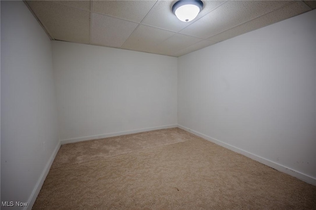 carpeted empty room featuring a paneled ceiling