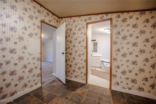 bathroom with a textured ceiling, vanity, and ornamental molding