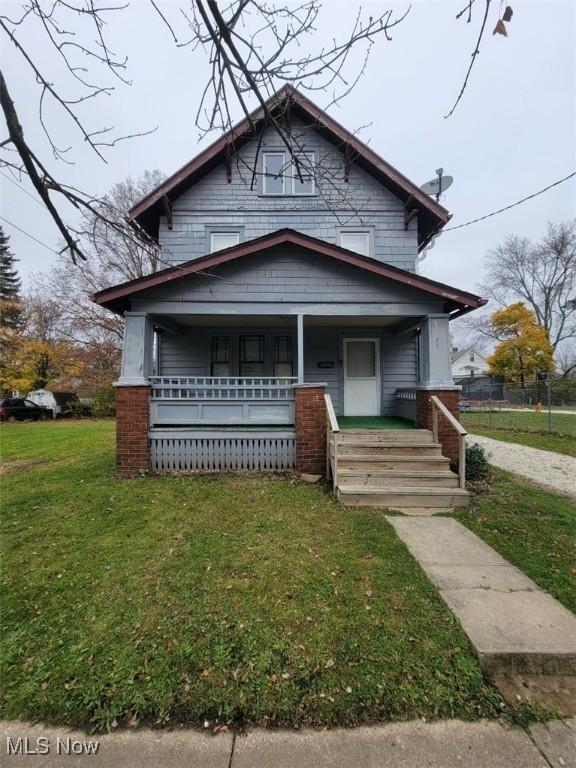 bungalow-style home with covered porch and a front yard