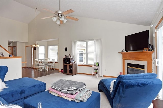 living room with lofted ceiling, carpet floors, ceiling fan with notable chandelier, and a textured ceiling