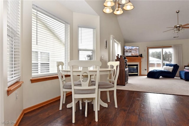 dining area with vaulted ceiling, dark hardwood / wood-style flooring, and ceiling fan with notable chandelier