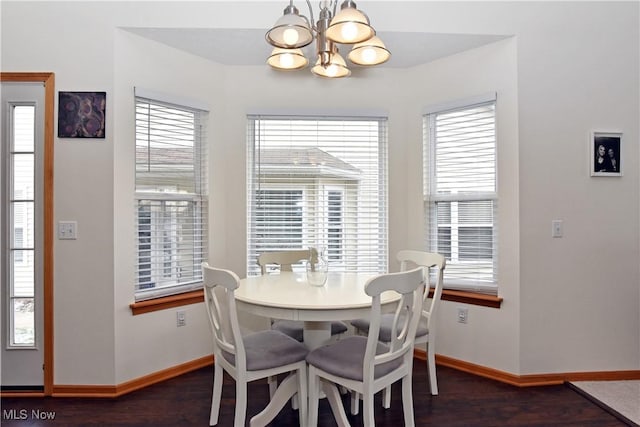 dining room with dark wood-type flooring, a notable chandelier, and a healthy amount of sunlight