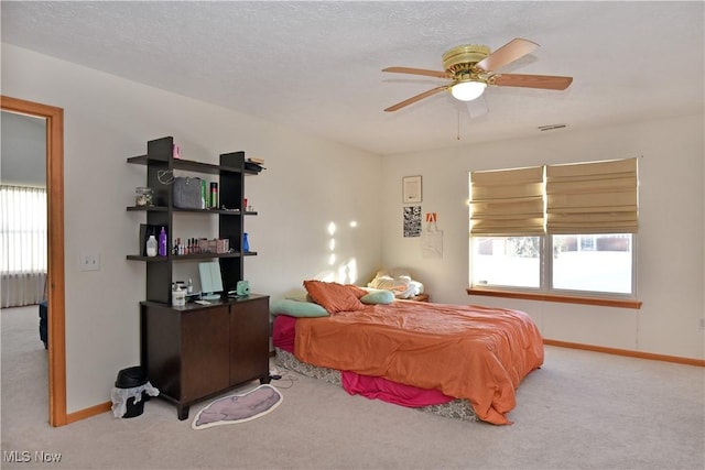 bedroom with ceiling fan, light colored carpet, and multiple windows