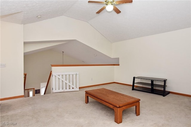 living area featuring ceiling fan, light colored carpet, a textured ceiling, and lofted ceiling