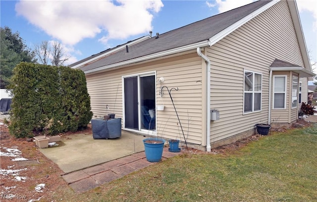 rear view of house featuring a lawn and a patio