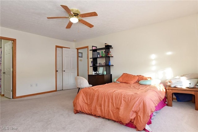 carpeted bedroom with ceiling fan, a closet, and a textured ceiling