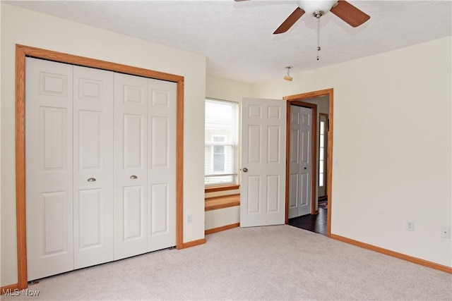 unfurnished bedroom with ceiling fan, a closet, and carpet