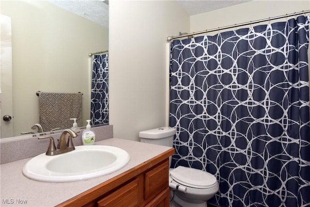 bathroom with a textured ceiling, toilet, and vanity