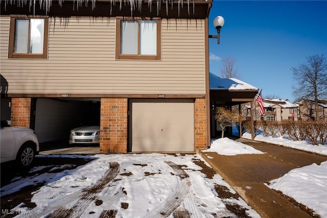 view of snow covered exterior featuring a garage