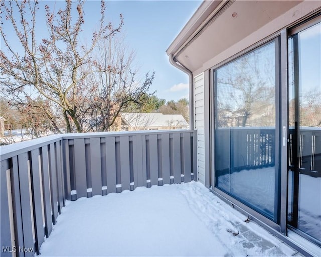 view of snow covered back of property