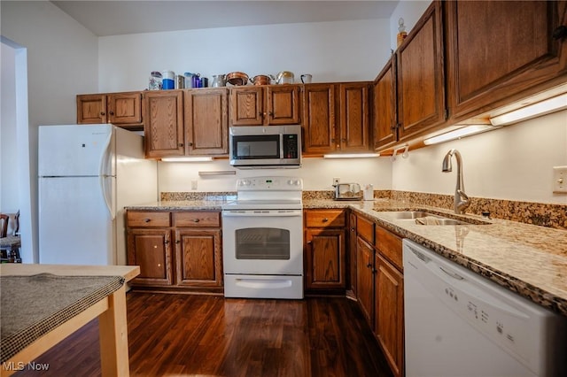 kitchen featuring dark hardwood / wood-style floors, sink, white appliances, and light stone counters