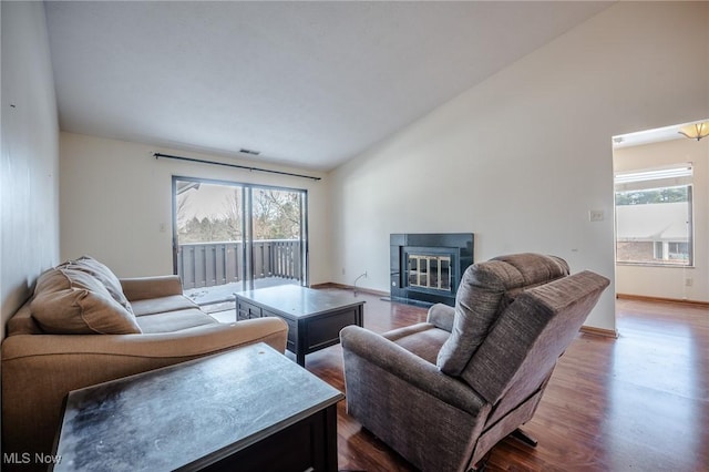 living room featuring lofted ceiling, a healthy amount of sunlight, and hardwood / wood-style flooring