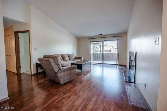 living room with dark hardwood / wood-style flooring and lofted ceiling