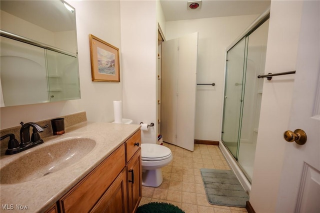 bathroom with toilet, vanity, and a shower with door