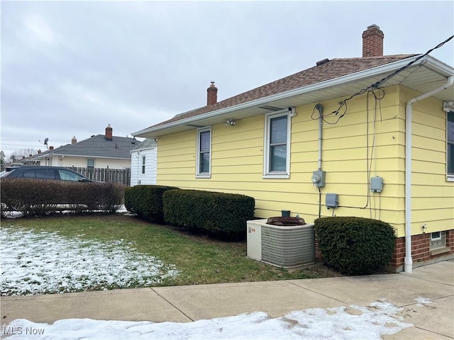 view of snowy exterior with central AC unit