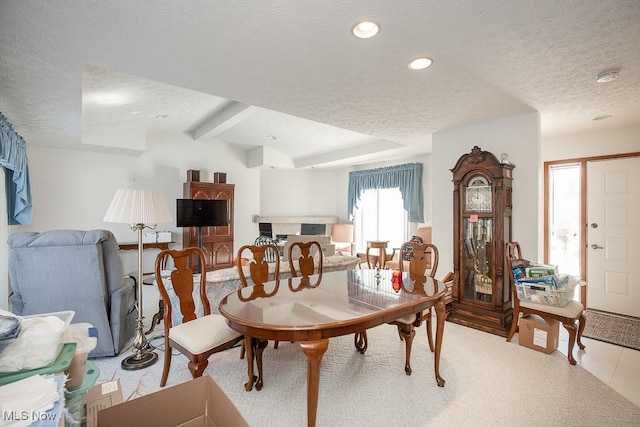 dining room with light tile patterned flooring, a textured ceiling, and beamed ceiling