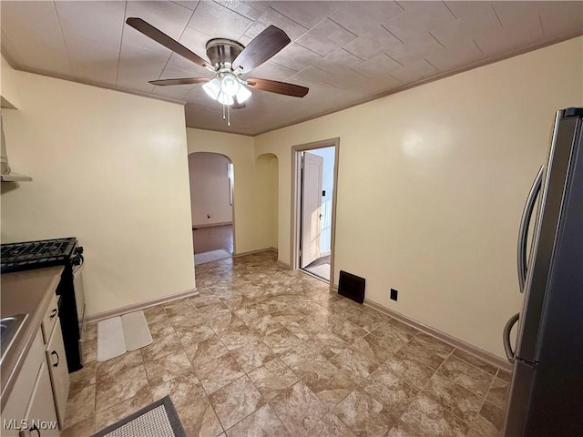 kitchen with ceiling fan, white cabinets, stainless steel refrigerator, and ornamental molding