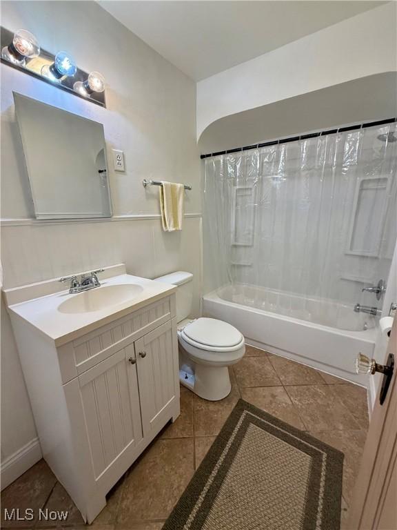 full bathroom featuring tile patterned floors, toilet, vanity, and shower / bathtub combination with curtain