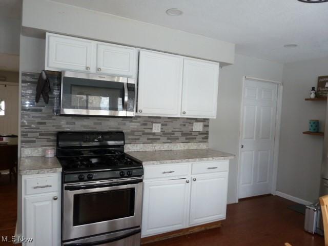 kitchen with white cabinetry, appliances with stainless steel finishes, and tasteful backsplash