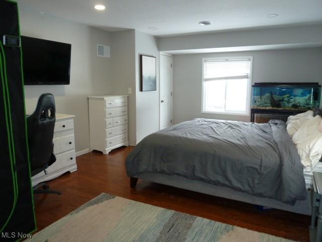 bedroom with dark hardwood / wood-style floors