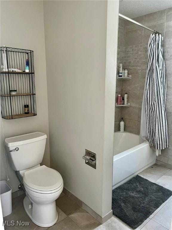 bathroom with toilet, tile patterned floors, and shower / tub combo with curtain