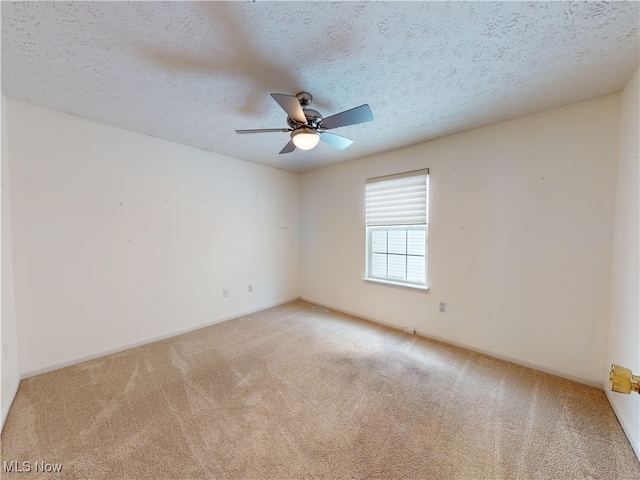 unfurnished room featuring a textured ceiling, ceiling fan, and carpet flooring