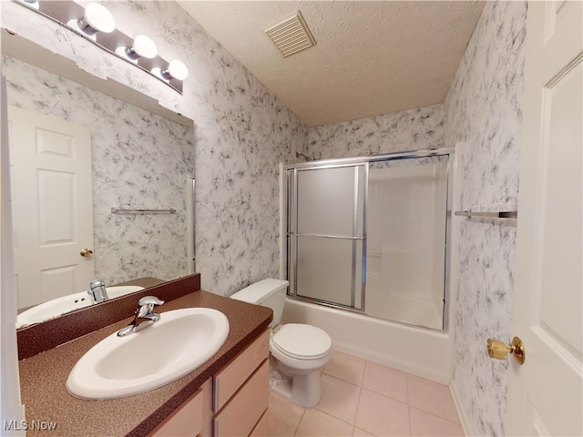 full bathroom with toilet, tile patterned floors, a textured ceiling, vanity, and shower / bath combination with glass door